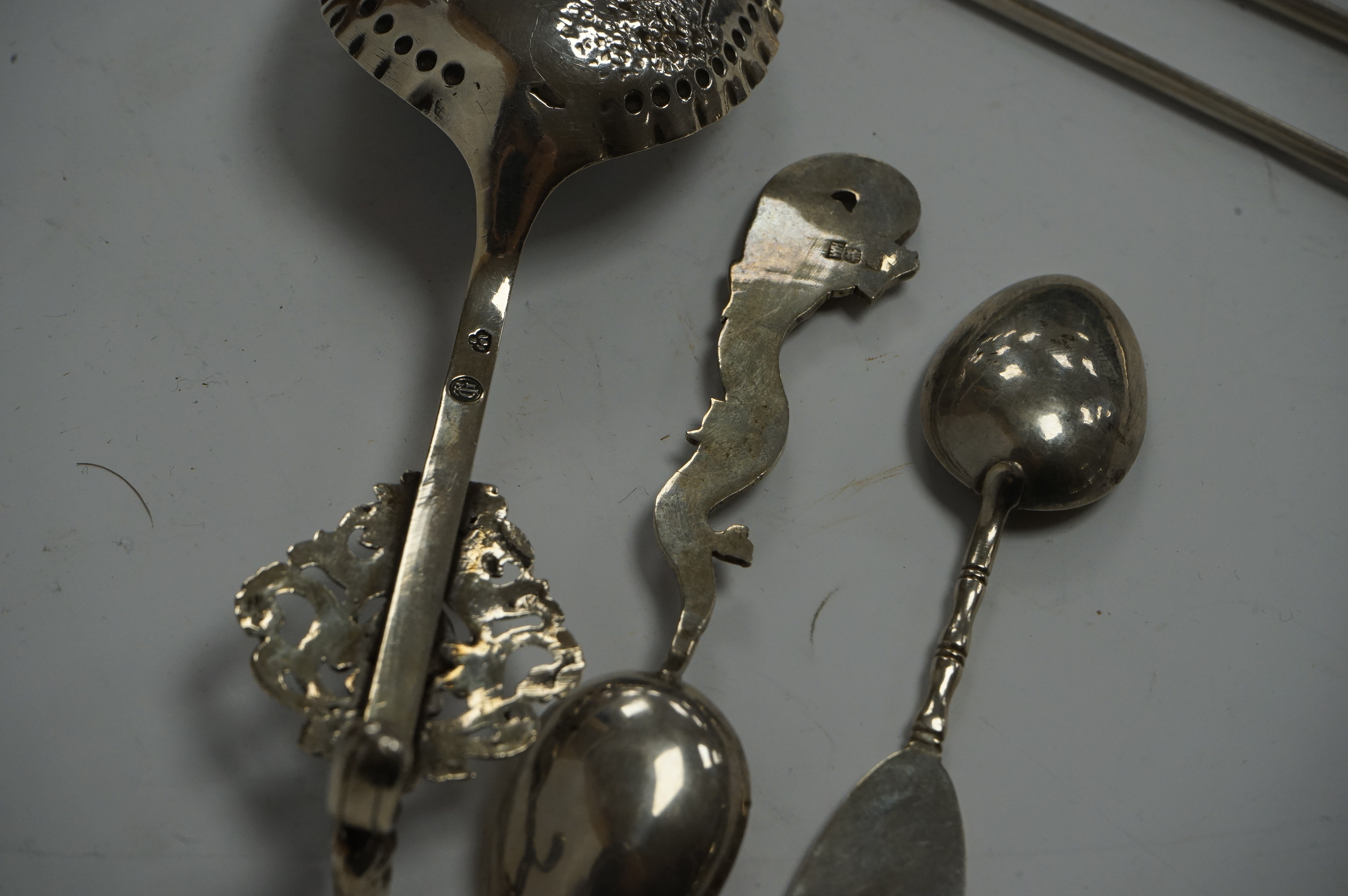 An early 19th century continental silver spoons, with embossed bowl and pieced terminal, import marks for Elly Isaac Miller, London, 1901, 17cm, together with two Chinese white metal spoons, one by Wang Hing and a pair o